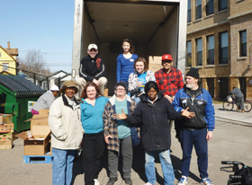 Soup kitchen volunteers help unload a food truck.